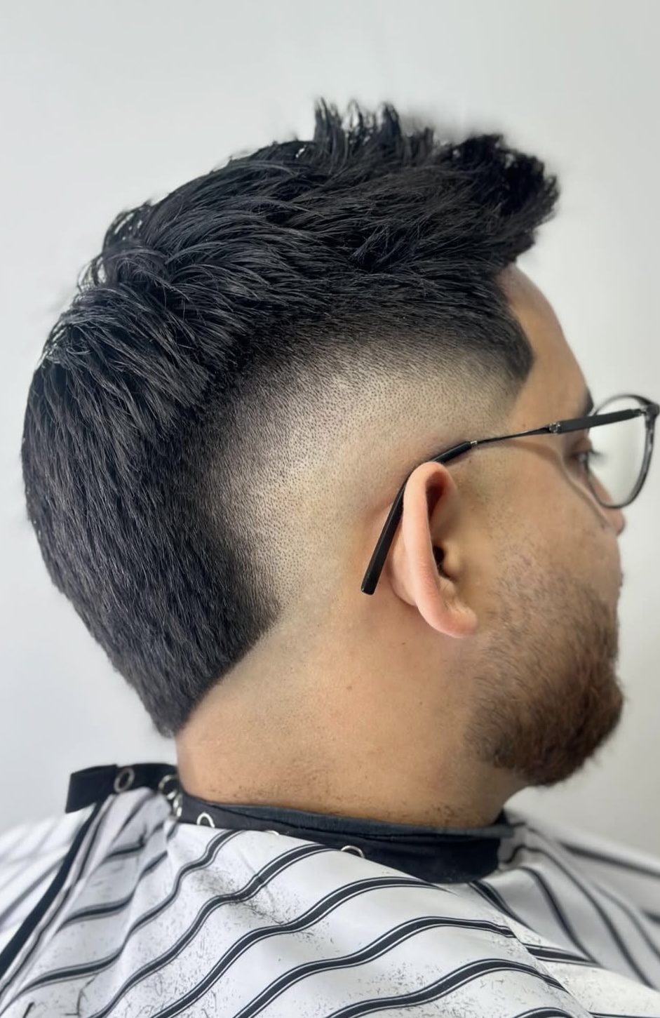 High skin fade with textured spiky top by Sharp Society Barbershop
